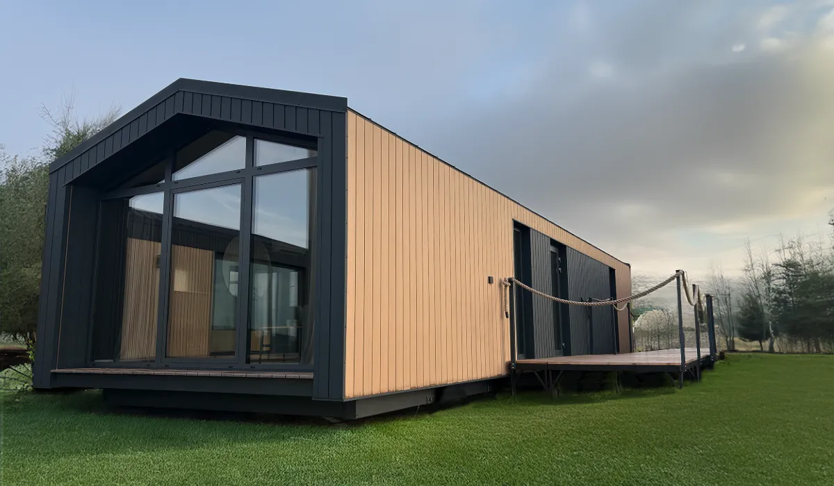 Modulodge model VELD modulaire woning met houten gevelpanelen, grote raampartijen en entree via terras