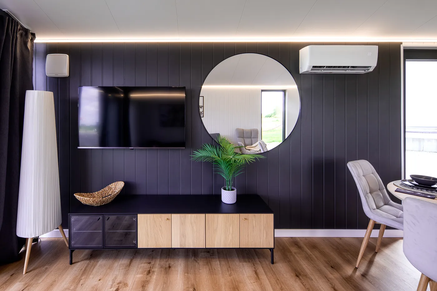 Interieur Modulodge model VELD woonruimte met tv-wand, design kast en moderne donkere wandbekleding