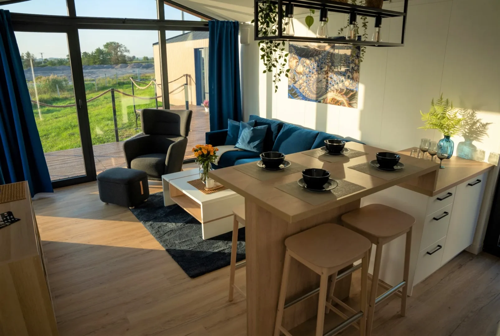 Interieur Modulodge model BOS woonruimte met open keuken, zithoek en grote ramen met uitzicht op natuur en terras